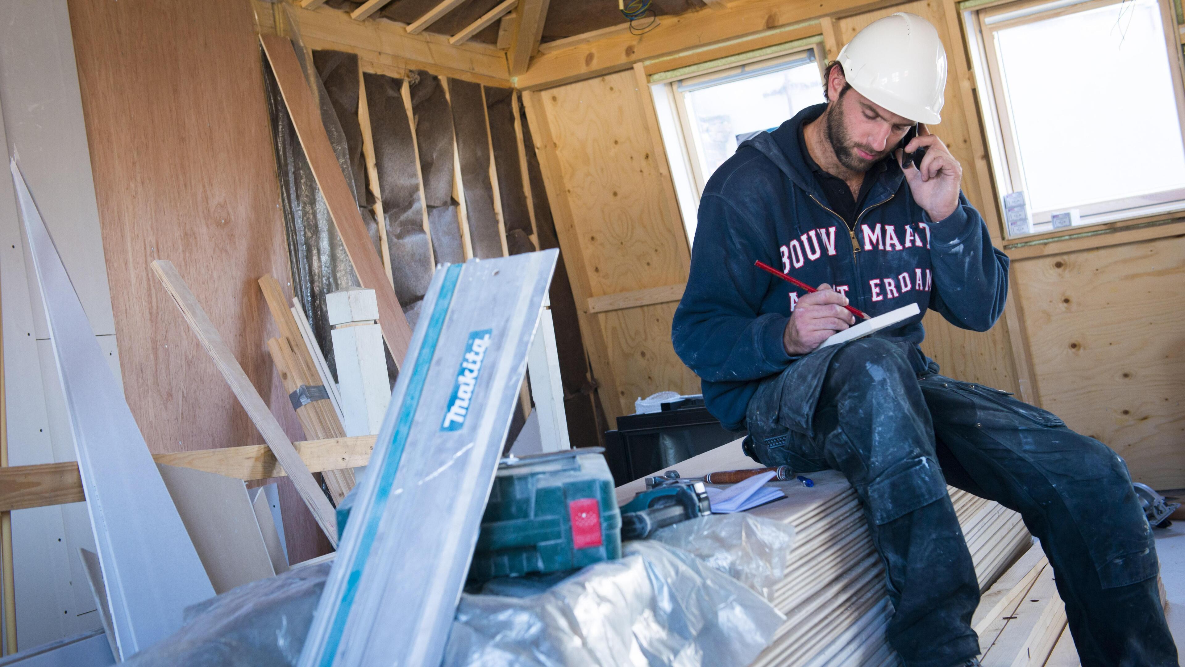 AMSTERDAM ILLUSTRATIE - Een bouwvakker plant zijn agenda. ANP XTRA ROOS KOOLE