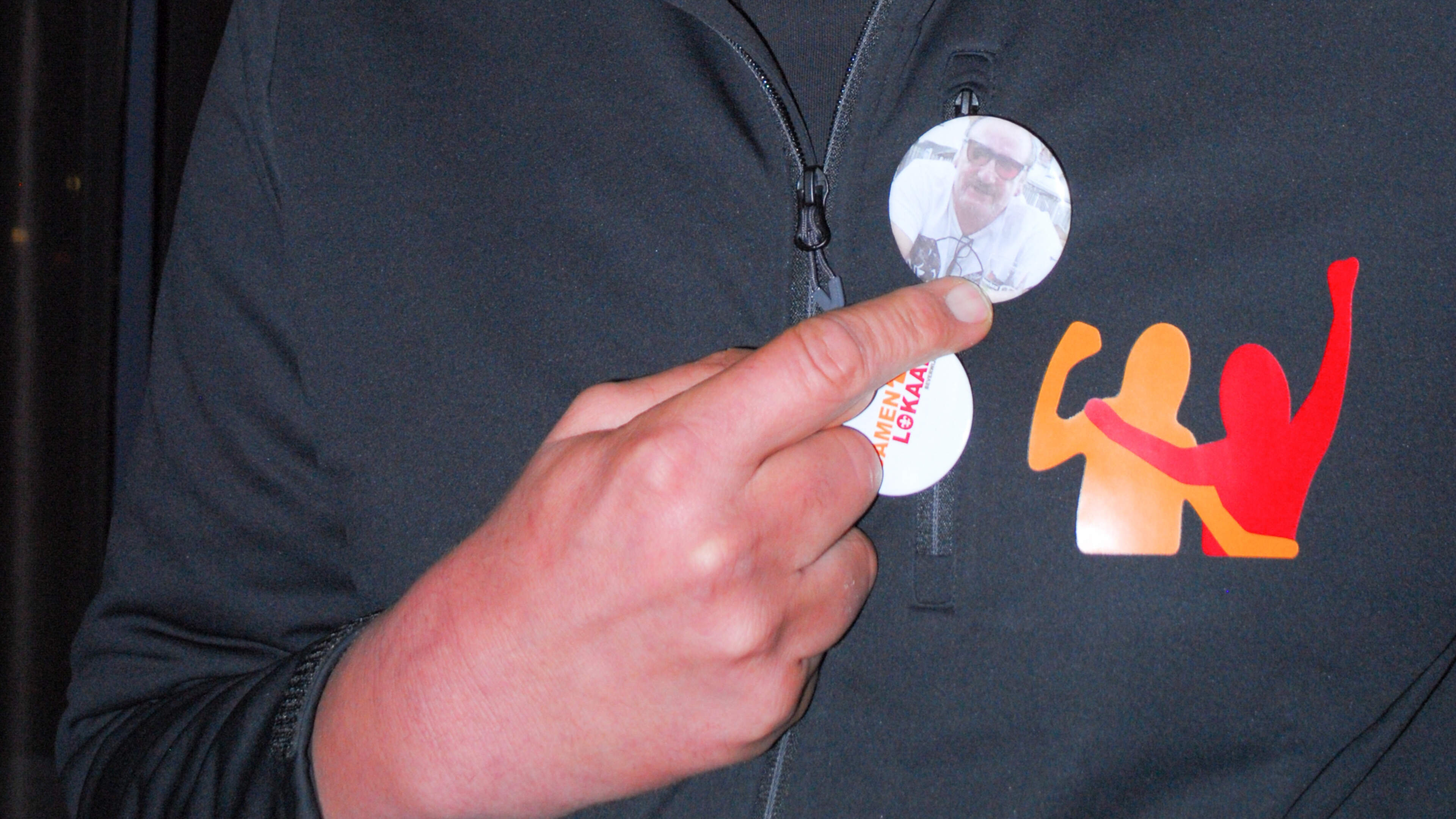 Sebastiaan wears two buttons: one with the party logo, the other with the face of his late father Alex van Luijn