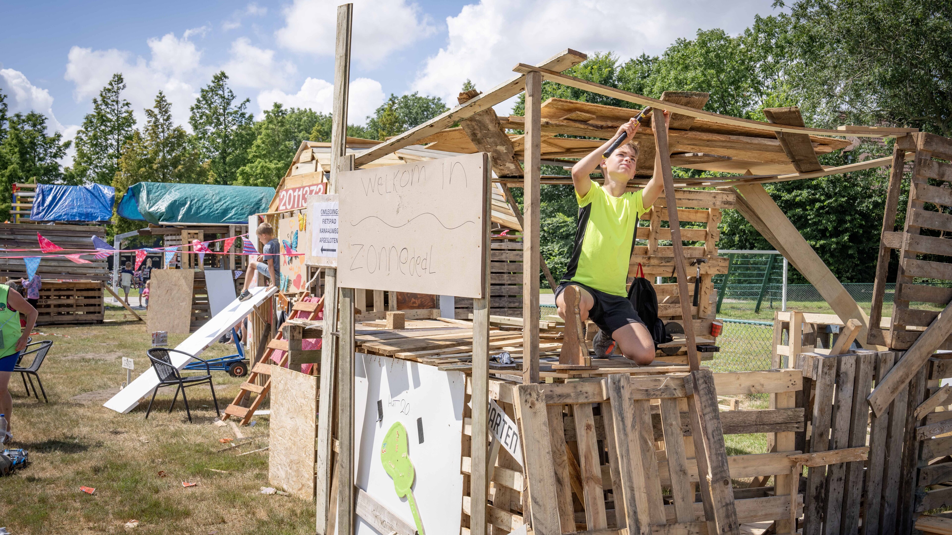 Een tijdelijke woonwijk aan De Weel in Hippolytushoef. Kinderen timmeren hun eigen hut