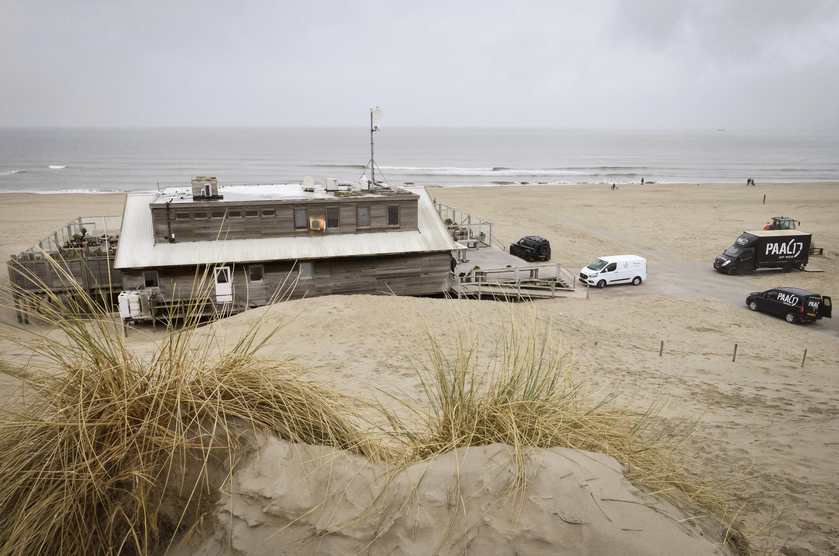 Hakken in het zand tegen zendmast op het strand. Callantsogers mordicus tegen 18 meter hoge spriet b