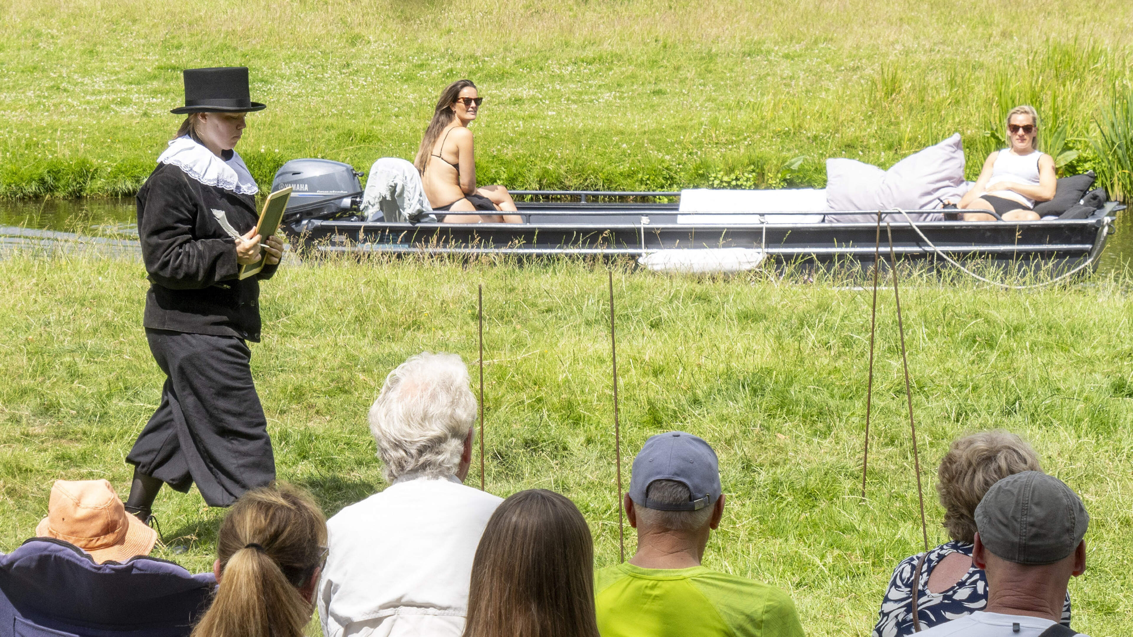 Schaars geklede dames in motorbootje passeren scène over Leeghwater. Toneelvereniging Benedictus spe
