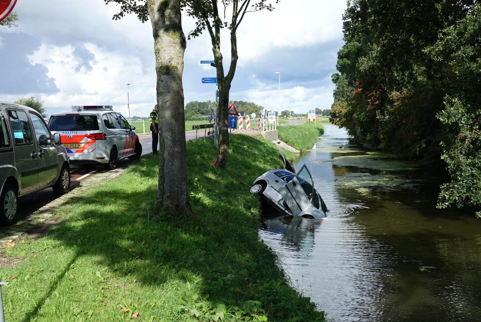 Omstanders helpen vrouw uit te water geraakte auto in Sijbekarspel
